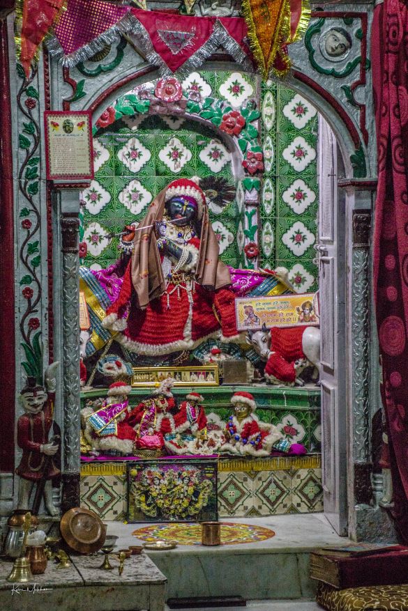 An idol of Lord Krishna dressed in Christmas clothing